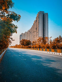 Street by buildings against blue sky