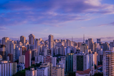 Aerial view of buildings in city against sky