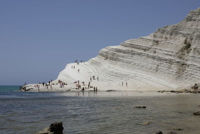 People at scala dei turchi against clear sky