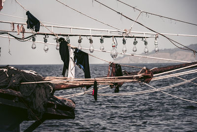 Clothes drying on rope at sea against sky