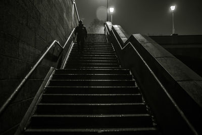 Low angle view of man moving down on steps at night