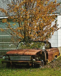 Abandoned car on field during autumn