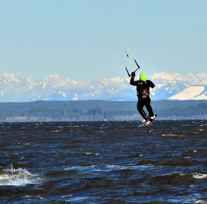 Rear view of a male kite surfer in action