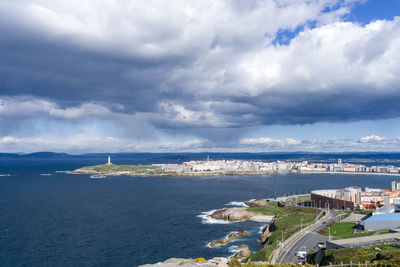 Scenic view of sea against sky, of the city of a coruña, with the hercules tower in the background