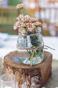 Close-up of white flowers in glass jar on table