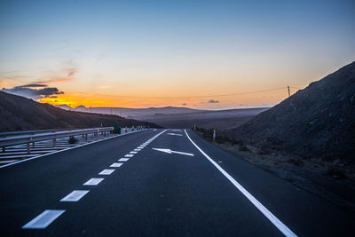 Road amidst landscape against sky during sunset