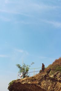 Man by tree against sky