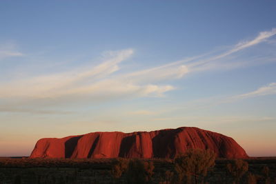 Rock formations on landscape against sky during sunset