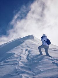 Low angle view of person photographing snowcapped mountain