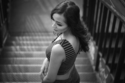 Beautiful woman standing by staircase