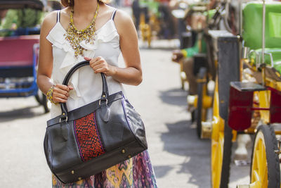 Woman holding leather handbag on the street