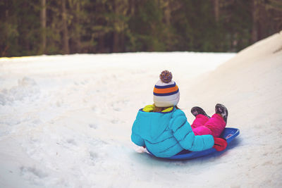 Full length of girl playing on snow covered land during winter