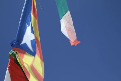 Low angle view of flag against blue sky