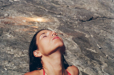 Low section of young woman standing on rock