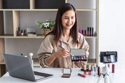 Portrait of young businesswoman working at table