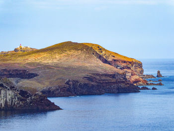 Scenic view of sea and mountains against clear sky