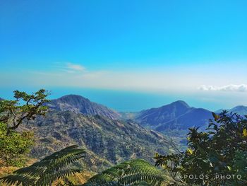 Scenic view of mountains against blue sky