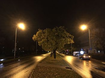 Illuminated road against sky at night