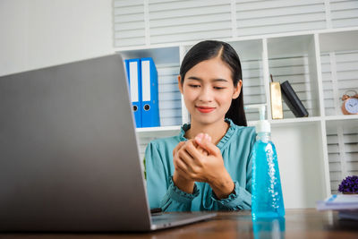 Portrait of woman using phone while sitting on table