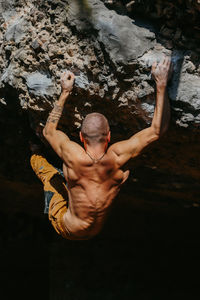 High angle view of man climbing rock