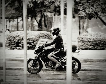 Side view of man riding motorcycle on road