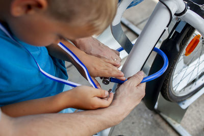 Close-up of boy repairing bicycle