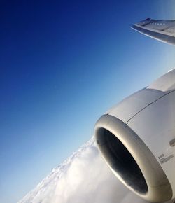 Low angle view of airplane flying against blue sky