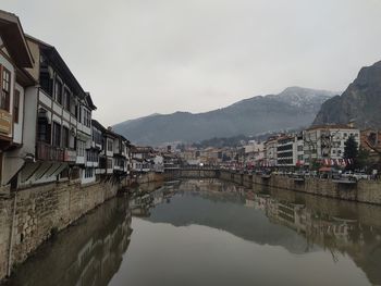 River amidst buildings in city against sky