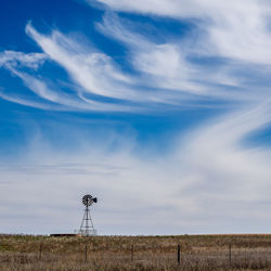 Wind turbine on land against sky