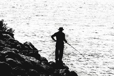Silhouette man fishing in sea