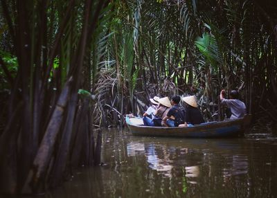 People sitting on boat in forest