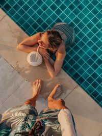 Low section of man standing by woman in swimming pool