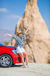 Full length of young woman standing on rock