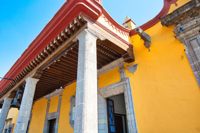 Low angle view of yellow building against sky