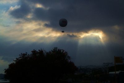 Low angle view of hot air balloons against cloudy sky