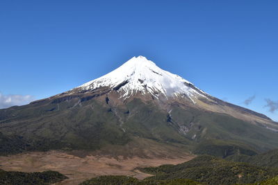 Scenic view of snowcapped mountains against clear blue sky