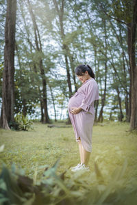 Full length of pregnant woman standing at park