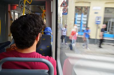 Rear view of man sitting in bus