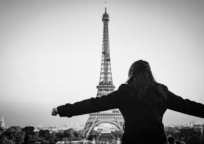 Rear view of people standing tower against sky