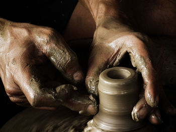 Cropped hands of man making pot in workshop