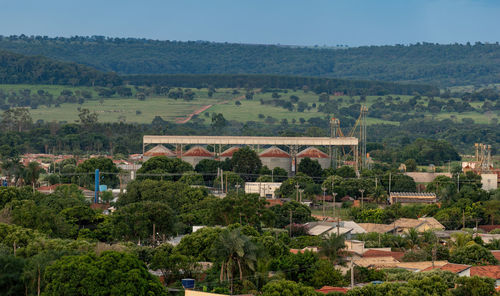 Trees and buildings in city against sky