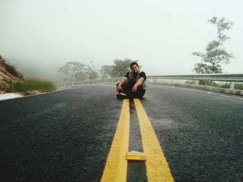 Portrait of man sitting on road