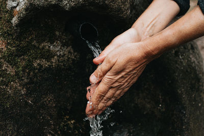 Midsection of person drinking water from pipe