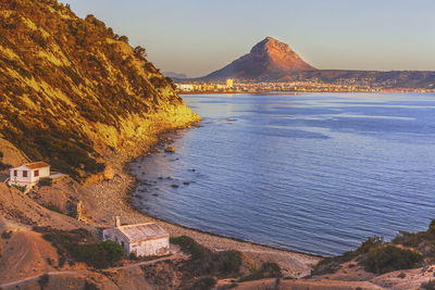 Scenic view of sea and mountains against sky