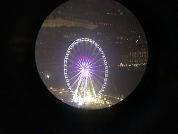 Low angle view of illuminated ferris wheel against sky at night