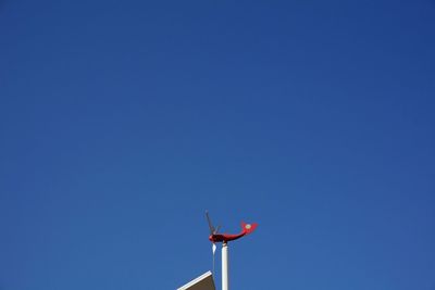 Low angle view of toy airplane against clear blue sky on sunny day