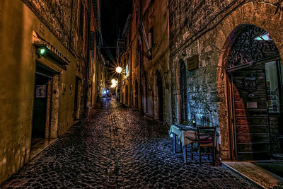 Narrow street along buildings at night