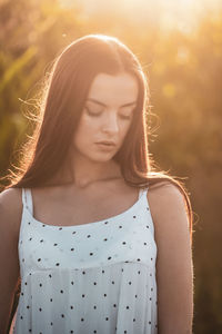 Young beautiful woman in white dress in corn field.