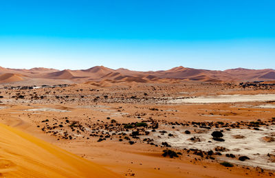 Scenic view of desert against clear blue sky