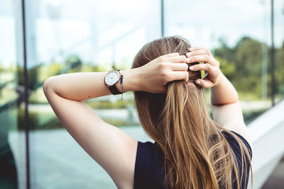 Woman tying hair in city